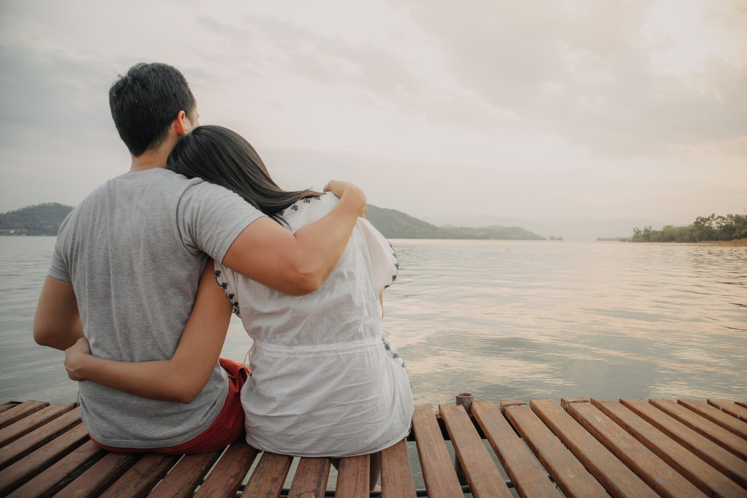 Asian lover couple hold together and admire the romantic beautiful lake landscape.