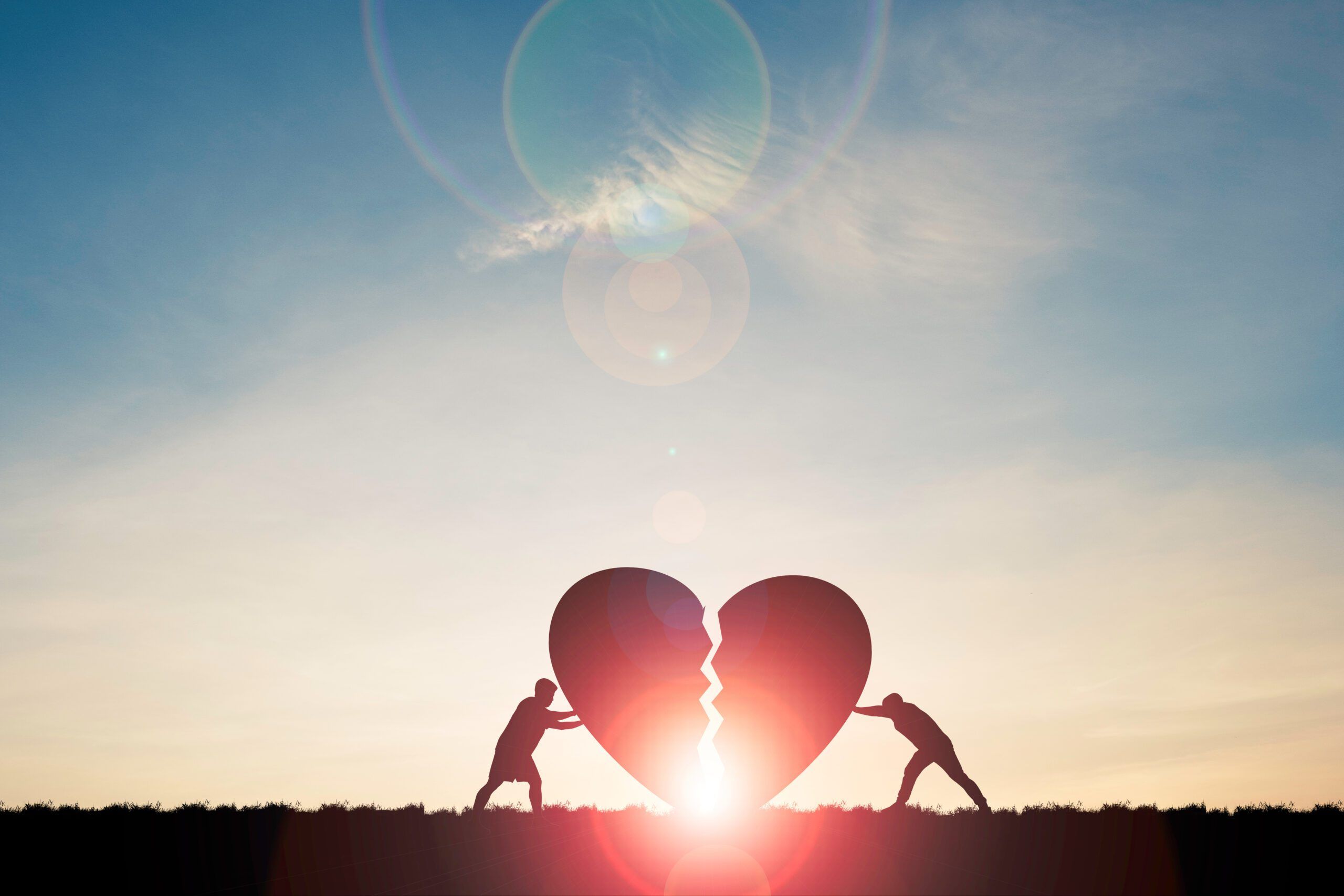 Two silhouette men pushing broken heart with sunlight and blue sky , Valentine 's day concept.